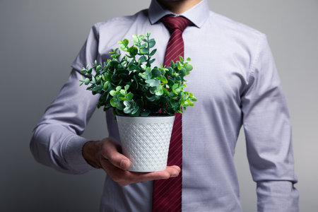 a man holding a pot of a plant .の写真素材