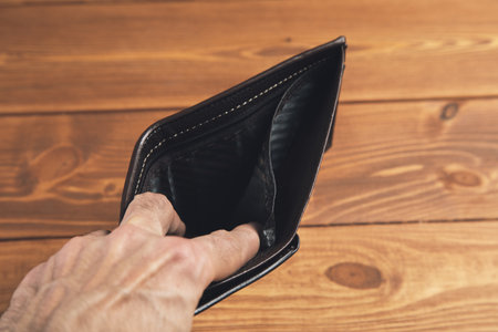 man holding an open empty skin walletの写真素材