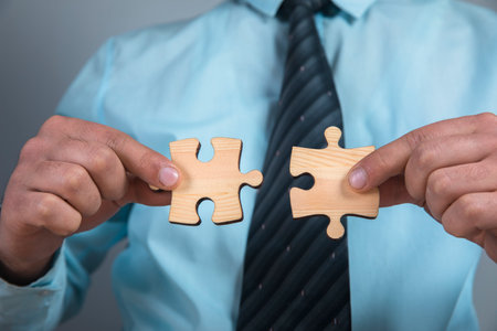 a man connects two puzzle piecesの写真素材