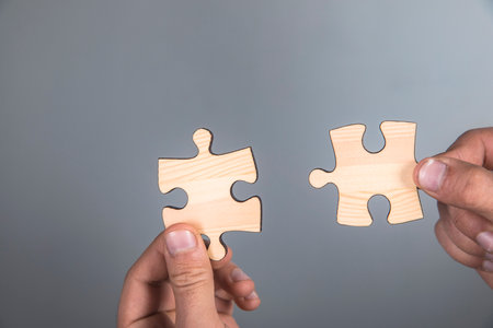 a man connects two puzzle piecesの写真素材