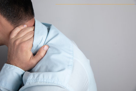 the man has a pain in the back of his head on a gray backgroundの写真素材