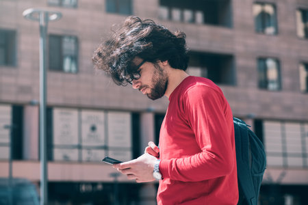 a young guy on the street sits on the phoneの写真素材