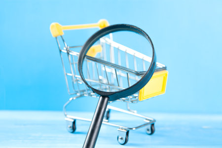 magnifier and basket. shopping search concept. on a blue wooden backgroundの写真素材