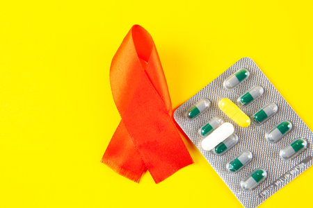 pills and red ribbon on yellow background