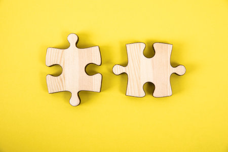 two pieces of a puzzle on a yellow backgroundの写真素材