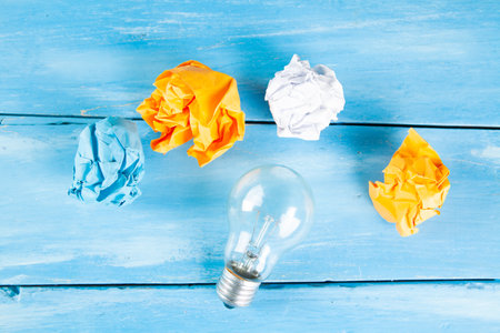wads of paper light bulb on blue wooden backgroundの写真素材