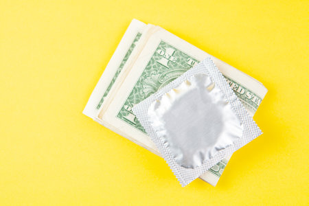 money condom on yellow backgroundの写真素材