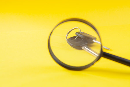 magnifier and keys on a yellow background. home searchの写真素材