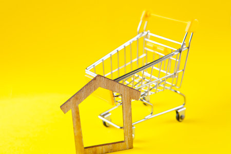 basket and house. home buying concept. on a yellow backgroundの写真素材