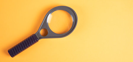 Magnifying glass on an orange background. Search concept.の写真素材