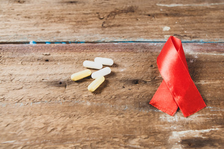 pills and red ribbon on the tableの写真素材