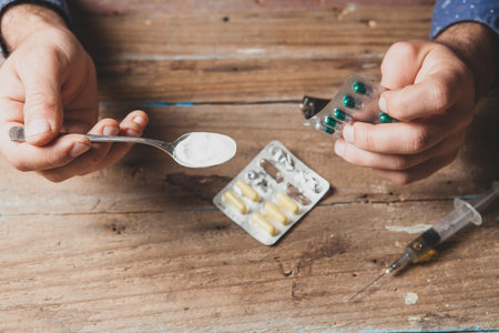 cocaine in a spoon and pills in hand. addict conceptの写真素材