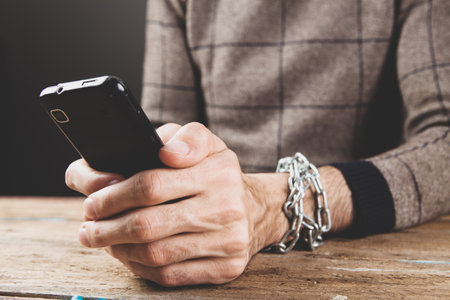 a man in handcuffs holding a phoneの写真素材