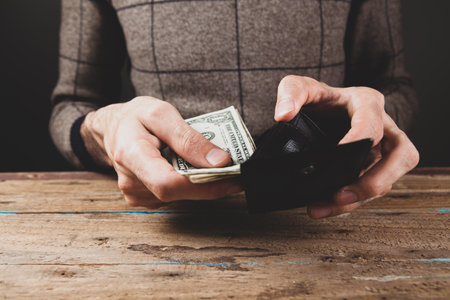 man pulls money out of walletの写真素材