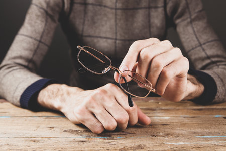 man holding optical glasses in his handの写真素材