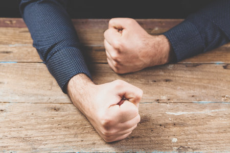 hits the table with his fistの写真素材