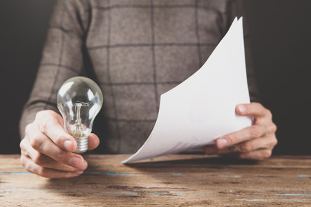 a man holding a lamp and statisticsの写真素材