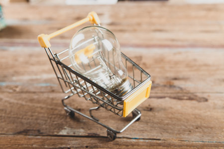 light bulb in a basket on a wooden backgroundの写真素材