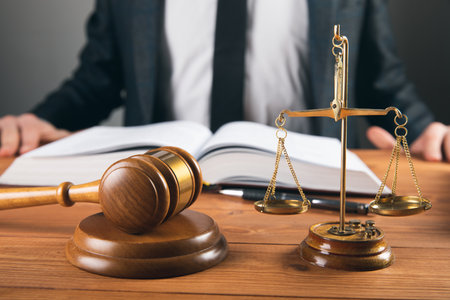 the judge takes notes and on the table scales and a hammer on a gray backgroundの写真素材