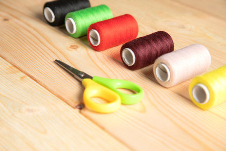 multicolored threads and scissors on wooden backgroundの写真素材