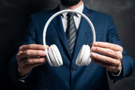 businessman holding headphones in his hand on a dark background