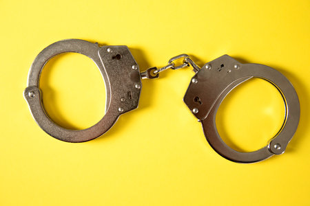 handcuffs on a yellow backgroundの写真素材