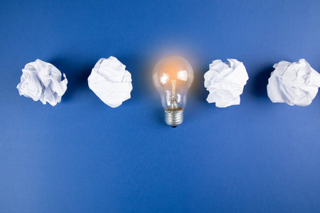 wad of paper and lamp on blue backgroundの写真素材