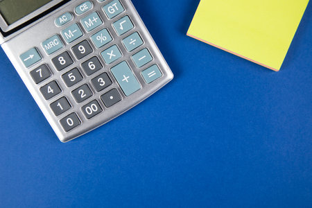there is a sticker and a calculator on the blue tableの写真素材