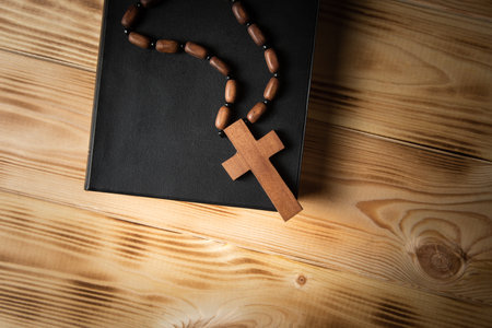 cross on a book on a wooden tableの写真素材