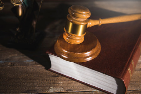 judge's hammer on a book on a wooden tableの写真素材