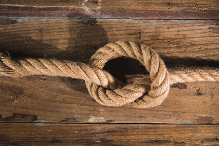Knot on a rope on a wooden background.の写真素材