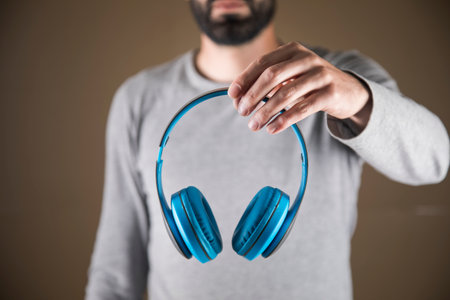 A man holding big headphones in his handsの写真素材