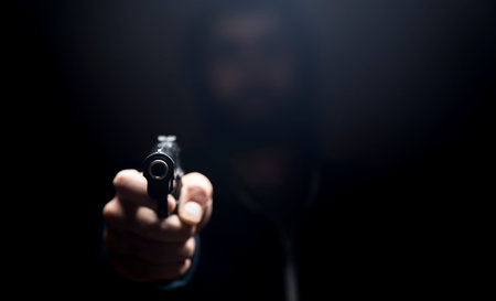 a man holding a pistol on a dark background