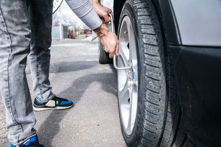 a man changes the wheel of a carの写真素材