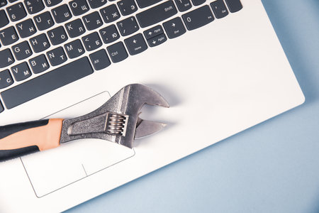 iron wrench on white laptopの写真素材