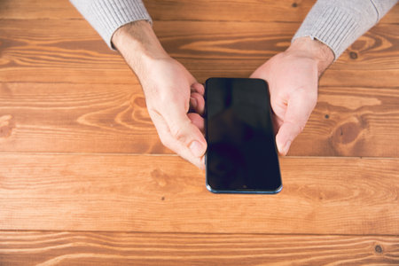 a man holding a phone in his handの写真素材