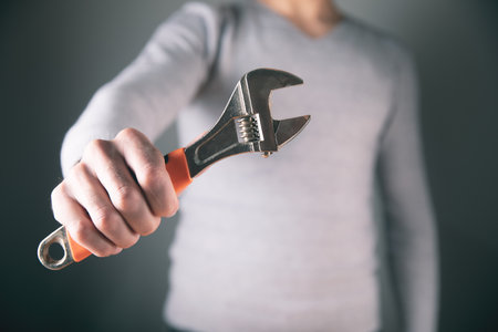 man in gray holding a wrenchの写真素材