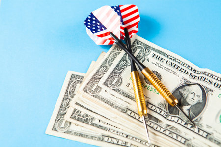 darts and money on a blue tableの写真素材