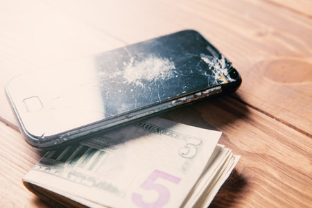 broken smartphone and money on the tableの写真素材