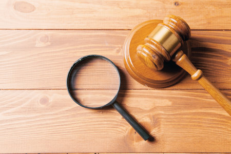 magnifying glass and gavel of the judge on the tableの写真素材