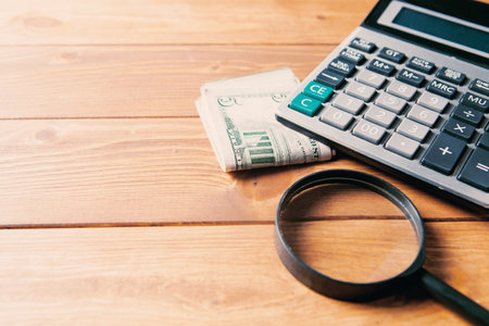magnifier, calculator and money on the table