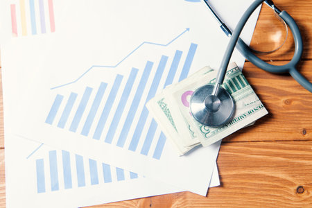 stethoscope on the money and stats on the lineの写真素材