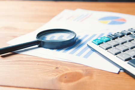concept explored costs. calculator, statistics and magnifying glass on the tableの写真素材