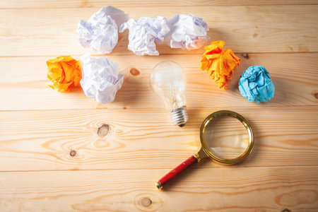 lamp, wad of paper magnifying glass on the tableの写真素材