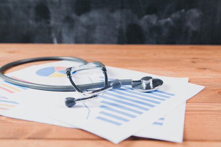 Stethoscope on a graphic charts on the tableの写真素材