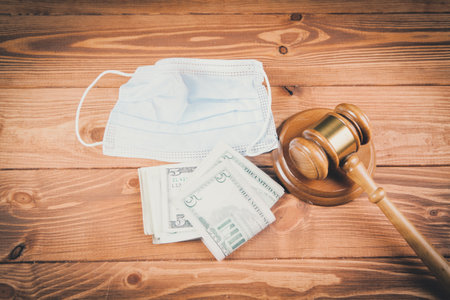 judge gavel with mask and money on the tableの写真素材
