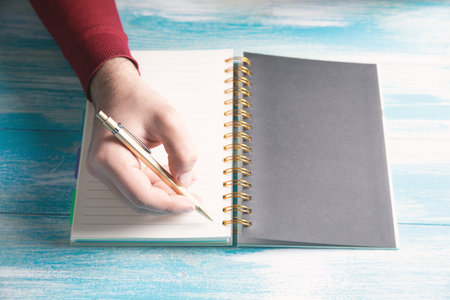 a young man writes in a notebook