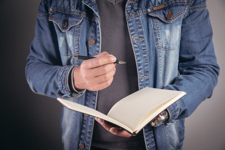 young man making notes in a notebookの写真素材
