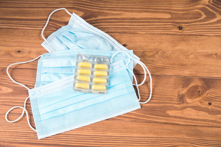 medical mask with pills on the wood tableの写真素材