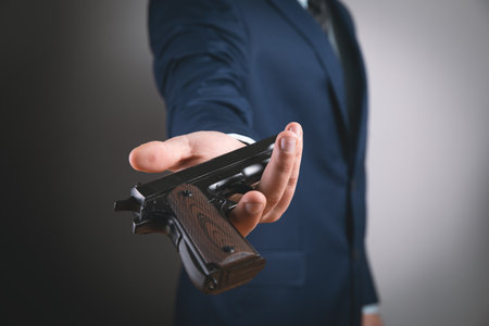 young man offers a black pistol.の写真素材